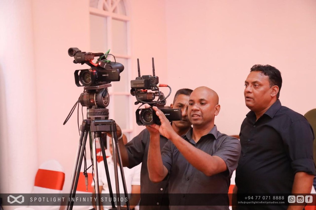 Videography crew operating multiple professional cameras at an indoor event