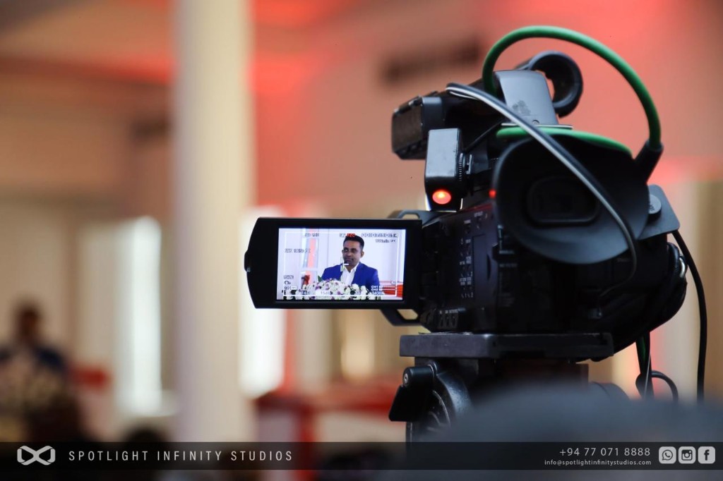 Professional video camera filming a speaker at a podium